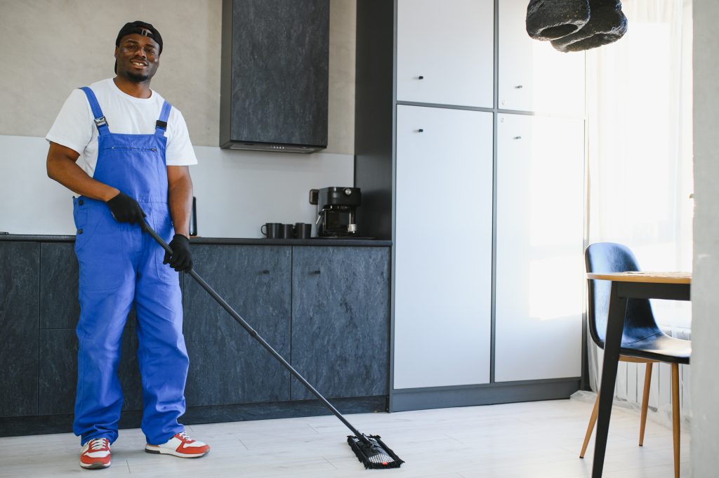 Housekeeper making bed and sanitizing surfaces in villa bedroom