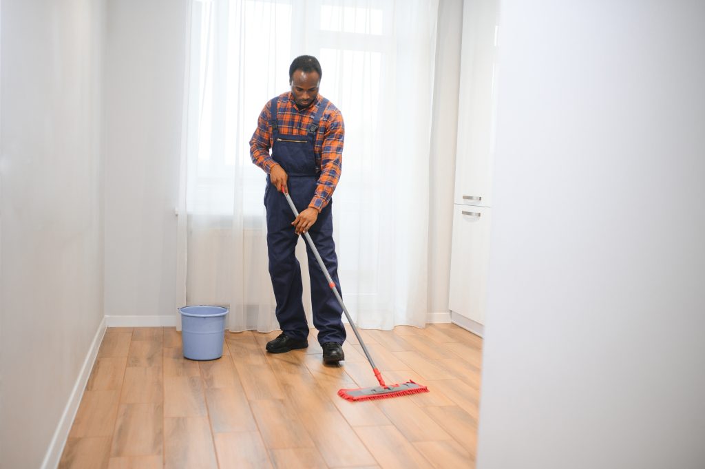 Cleaner scrubbing marble floors in a spacious Dubai villa kitchen